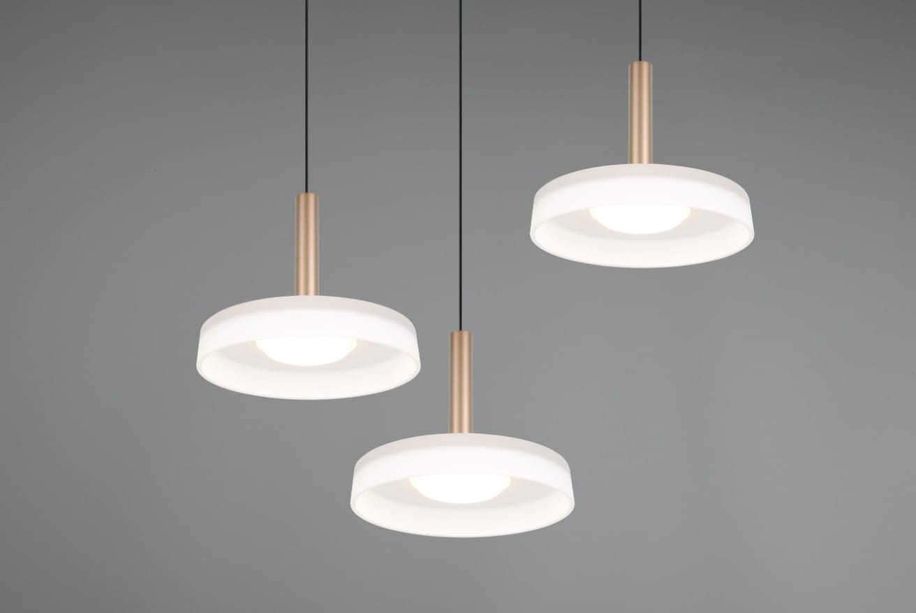 Lampa wisząca Celeste z trzema źródłami światła LED, o mocy 22,5W, w kolorze białym i kawowym. Okrągłe klosze z matowego szkła zawieszone na złotych rurkach, wisi w poziomie, na jednolitym tle.