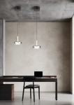 Lampa wisząca Celeste w kolorze czarnym i chromowym z jedną diodą LED 10W. Zawieszona na cienkim kablu, z okrągłym kloszem i drewnianym detalem, umieszczona nad biurkiem w minimalistycznym wnętrzu.