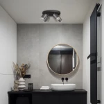 Czarna lampa sufitowa Turyn IP44 z czterema reflektorami GU10, zamontowana na suficie w łazience. Oświetlenie skierowane jest w różnych kierunkach, w otoczeniu minimalistycznego wnętrza z okrągłym lustrem i ciemnym blatem.