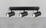 Lampa sufitowa Nicea z trzema reflektorami GU10 w kolorze czarnym i złotym. Ułożona równolegle do sufitu, z cylindrycznymi oprawami o teksturowanej powierzchni, z widocznymi białymi wnętrzami. Zainstalowana na prostokątnej, czarnej podstawie.