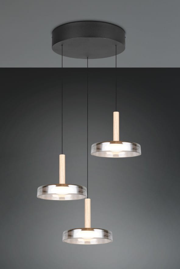 Lampa wisząca Celeste z trzema źródłami LED, o mocy 22,5W, w kolorze czarnym i chromowanym. Posiada drewniane uchwyty oraz szklane klosze w kształcie okręgów, zawieszona na cienkich linkach z sufitu.