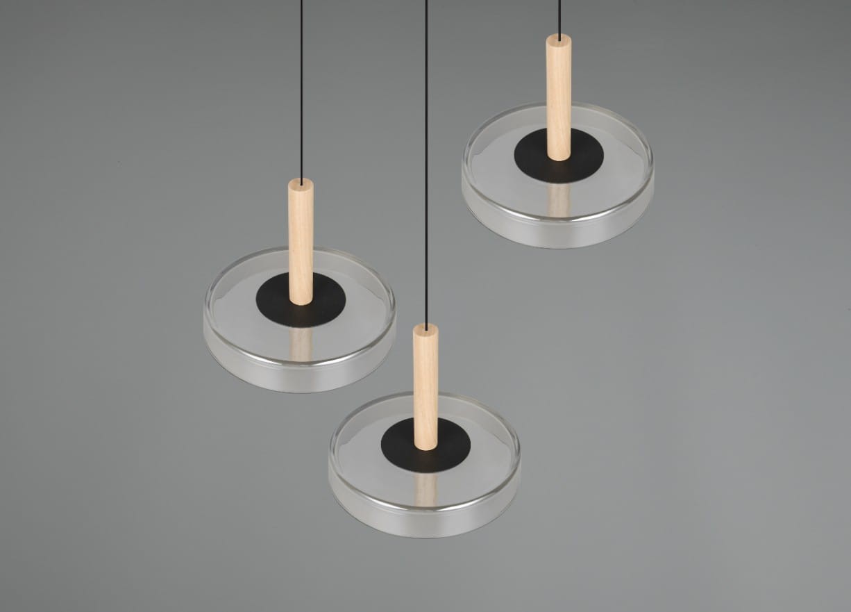 Lampa wisząca Celeste z trzema kloszami LED, o średnicy 22,5 cm, w kolorze czarnym i chromowanym. Klosze wykonane z przezroczystego tworzywa, z drewnianymi uchwytami. Zawieszona na cienkich, czarnych linkach, na szarym tle.