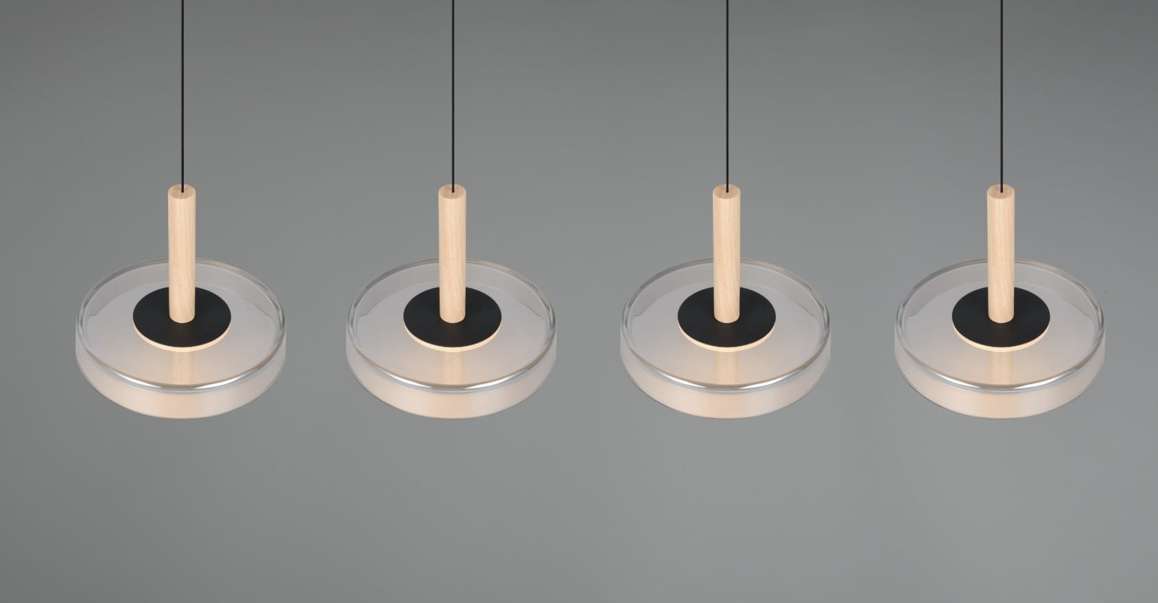 Lampa wisząca Celeste w kolorze czarnym i chromowanym, z czterema źródłami LED. Posiada przezroczyste klosze z okrągłymi podstawami oraz drewniane uchwyty. Zawieszona na cienkich, czarnych linkach, w nowoczesnym, minimalistycznym stylu.