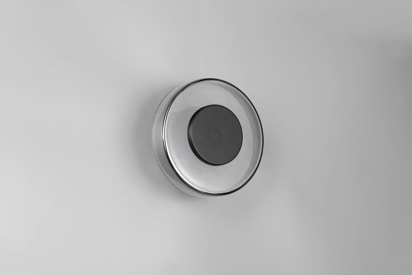 Plafon Celeste 1xLED/10W w kolorze czarnym i chromowanym, o okrągłym kształcie. Umieszczony na gładkiej, jasnej powierzchni, z centralnym czarnym elementem. Widoczny z góry, pokazujący jego minimalistyczny design.