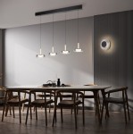Plafon Celeste 1xLED/10W w kolorze czarnym i chromowanym, zawieszony na długich linkach, z czterema okrągłymi kloszami. Ujęcie z przodu, w nowoczesnej aranżacji jadalni z drewnianymi krzesłami i okrągłym stołem.