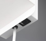 Kinkiet Comfort w białym kolorze z portem USB-C. Widoczny detal gniazda USB-C oraz przewód zasilający. Kąt ujęcia zbliżony, ukazujący dolną część lampy. Tło szare, neutralne.