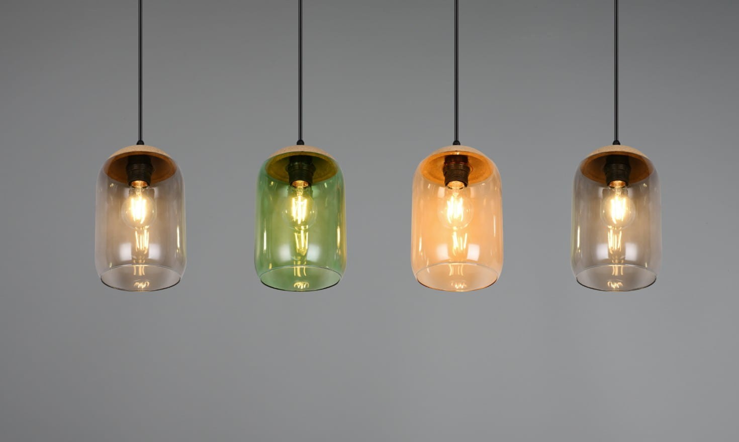 Lampa wisząca Cork w kolorze czarnym z czterema kloszami w różnych kolorach: przezroczystym, zielonym, pomarańczowym i szarym. Klosze mają okrągły kształt, a każdy z nich zawiera żarówkę E27. Produkt zawieszony na cienkich, czarnych linkach.