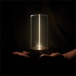 Lampa stołowa Esterno w kolorze szarym, z przezroczystym kloszem i metalową podstawą. Zbliżenie na lampę trzymaną w dłoni, źródło światła LED umieszczone centralnie. Wodoszczelność IP44, idealna do użytku wewnętrznego i zewnętrznego.