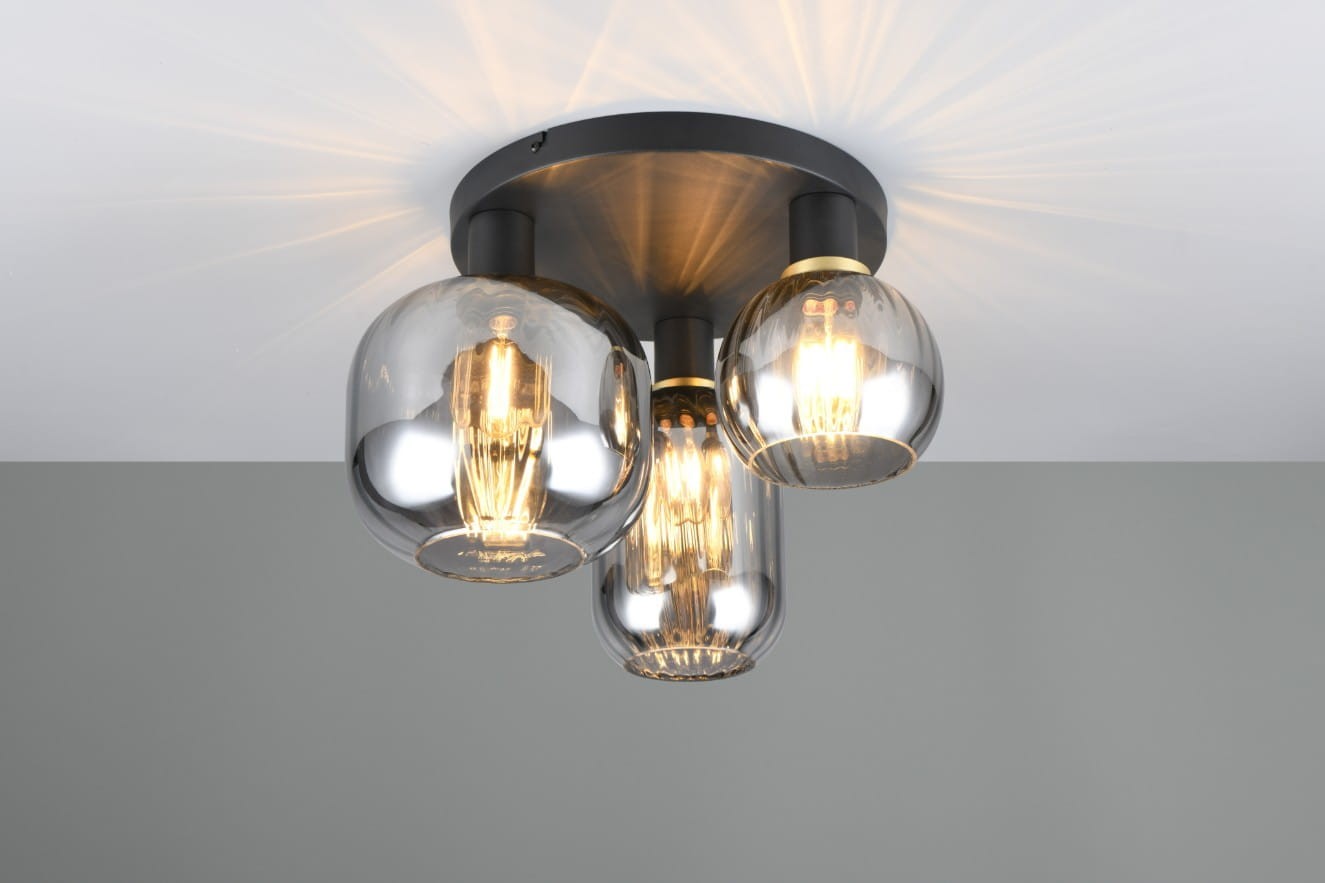 Lampa sufitowa Diva z trzema oprawami E27 w kolorze czarnym i chromowanym. Szklane klosze w różnych kształtach, emitujące ciepłe światło. Montaż sufitowy, widok z góry, na jednolitym tle.