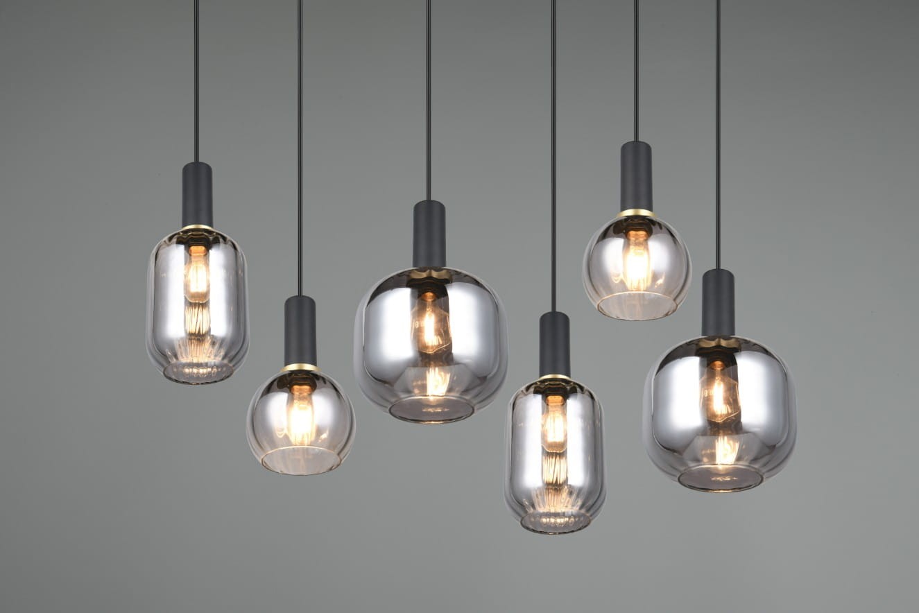 Lampa wisząca Diva z sześcioma kloszami E27 w kolorze czarnym i chromowanym. Klosze w różnych kształtach, wykonane ze szklanych elementów, zawieszone na cienkich linkach, tworzą nowoczesną kompozycję. Tło w odcieniach szarości.