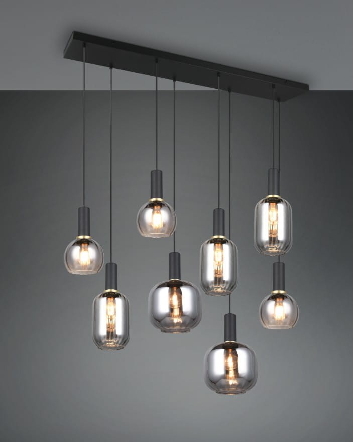 Lampa wisząca Diva z ośmioma żarówkami E27 w kolorze czarnym i chromowanym. Szklane klosze w różnych kształtach, zawieszone na cienkich linkach, zamontowane na prostokątnej podstawie. Tło w jednolitym szarym kolorze.