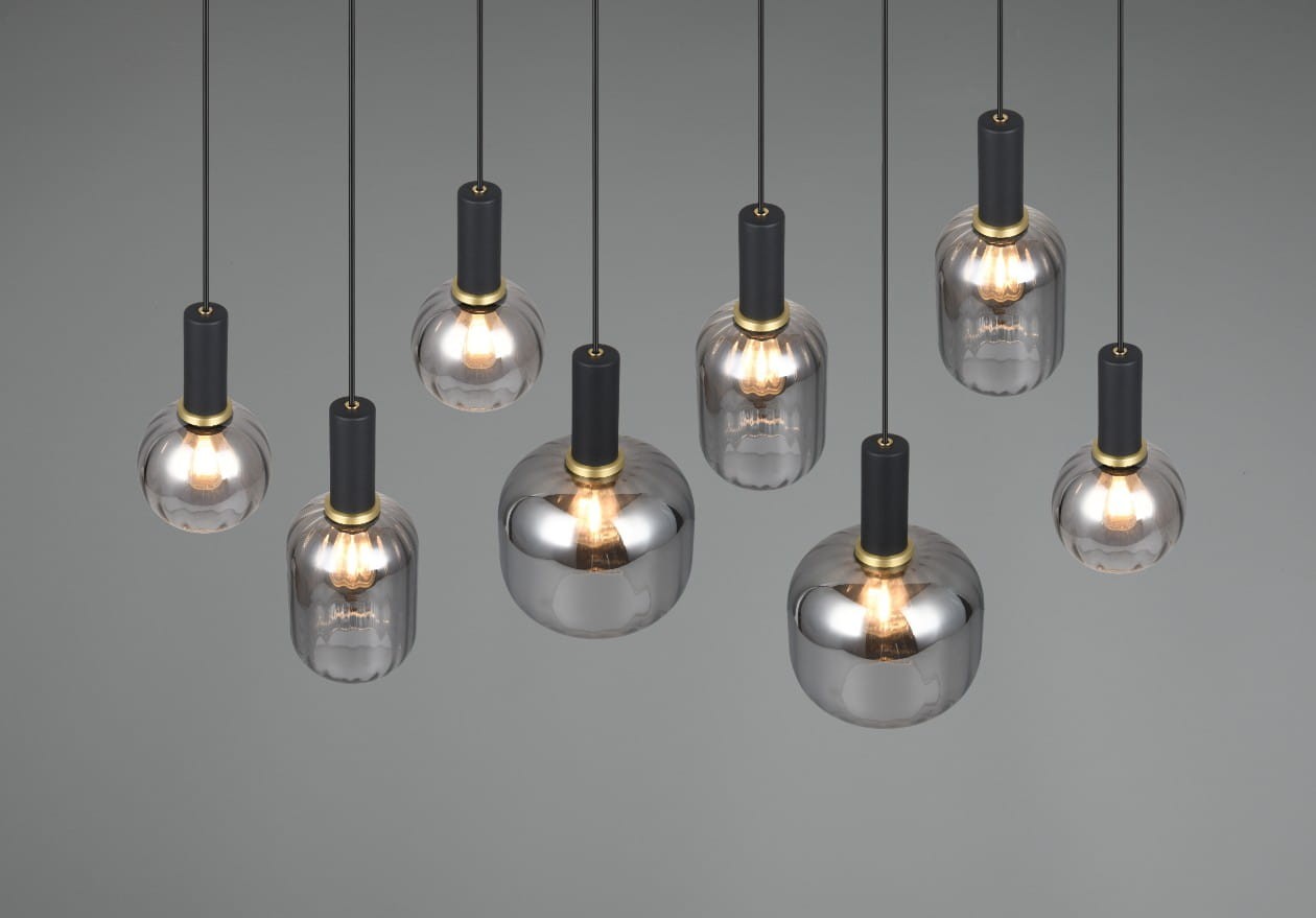Lampa wisząca Diva z ośmioma źródłami E27, w kolorze czarnym i chromowanym. Szklane klosze o różnych kształtach zawieszone na cienkich linkach, z czarnymi, matowymi uchwytami i złotymi detalami. Ujęcie z góry, na jednolitym tle.