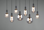 Lampa wisząca Diva z 8 oprawami E27, w kolorze czarnym i chromowanym. Wisi na cienkich kablach, z różnymi kształtami kloszy: okrągłe i cylindryczne, wykonane z przezroczystego szkła, z widocznymi żarówkami. Tło szare.