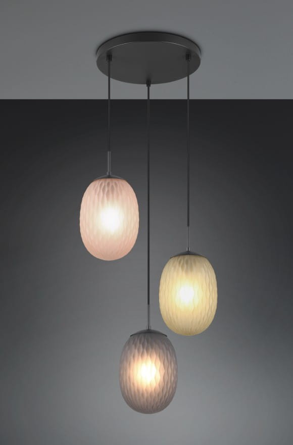 Lampa wisząca Facette z trzema kloszami w kolorach: różowym, żółtym i szarym, zawieszona na cienkich linkach z czarnym stelażem. Klosze mają teksturowaną powierzchnię, emitując ciepłe światło. Wymiary i szczegóły montażu niewidoczne.