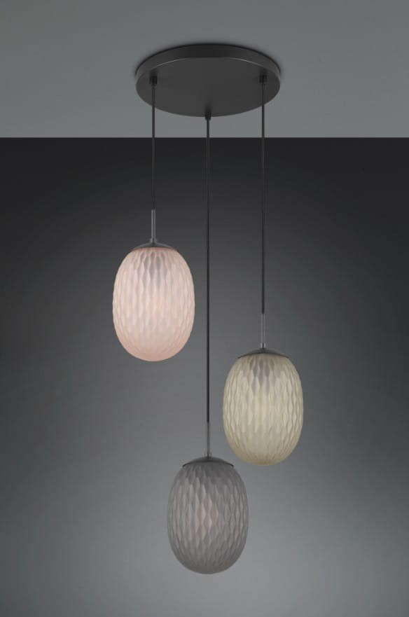 Lampa wisząca Facette z trzema kloszami w kształcie owalnym, wykonanymi z matowego szkła w odcieniach różowym, szarym i białym. Zawieszona na cienkich przewodach, montowana na okrągłej czarnej podstawie sufitowej.