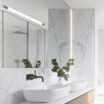Kinkiet Parks 1xLED/9W/3000K w chromowanej obudowie, zamontowany nad umywalkami w nowoczesnej łazience. Oświetlenie z białym światłem, na tle marmurowych płytek i lustra, w otoczeniu roślinności.