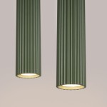 Lampa wisząca Karbon 2 w kolorze oliwkowym z dwoma cylindrycznymi kloszami z rowkowanej tekstury. Ujęcie z bliska, ukazujące detale wykończenia oraz otwarte dolne części kloszy z żarówkami GU10. Tło w neutralnym odcieniu.