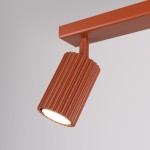 Karbon lampa sufitowa (spot) 3xGU10 w kolorze ochra czerwona, z cylindrycznym kloszem o żłobionej fakturze, zamontowana na prostokątnej podstawie. Ujęcie z boku, prezentujące detal klosza i jego oświetlenie.