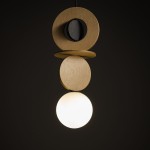 Lampa wisząca Drops Wood A z czarnym akcentem i jasnym drewnem, składająca się z trzech okrągłych elementów oraz białej szklanej kuli. Ujęcie z góry, produkt zawieszony na cienkim przewodzie, na ciemnym tle.