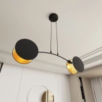 Lampa wisząca Motif z dwoma źródłami światła E14, w kolorze czarnym i złotym. Posiada zaokrąglone klosze o matowej powierzchni z wnętrzem w kolorze złotym, zawieszona na cienkich linkach, w nowoczesnym stylu.