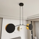 Lampa wisząca Motif z dwoma źródłami światła E14, w kolorze czarnym i złotym. Posiada dwa okrągłe klosze, jeden z czarnym wykończeniem, drugi z złotym wnętrzem, zawieszona na cienkich linkach. Montaż sufitowy, nowoczesny styl.
