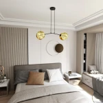 Lampa wisząca Motif 2xE14 w kolorze złotym i czarnym, z dwoma okrągłymi kloszami, zawieszona na czarnej konstrukcji. Widok z góry, w aranżacji sypialni z jasnymi ścianami i nowoczesnym wystrojem.