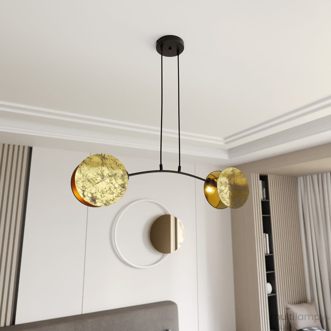 Lampa wisząca Motif 2xE14 w kolorze złotym i czarnym, z dwiema okrągłymi, złotymi kloszami na czarnym stelażu. Zawieszona na dwóch cienkich linkach, w nowoczesnym wnętrzu z jasnym tłem i okrągłym lustrem.
