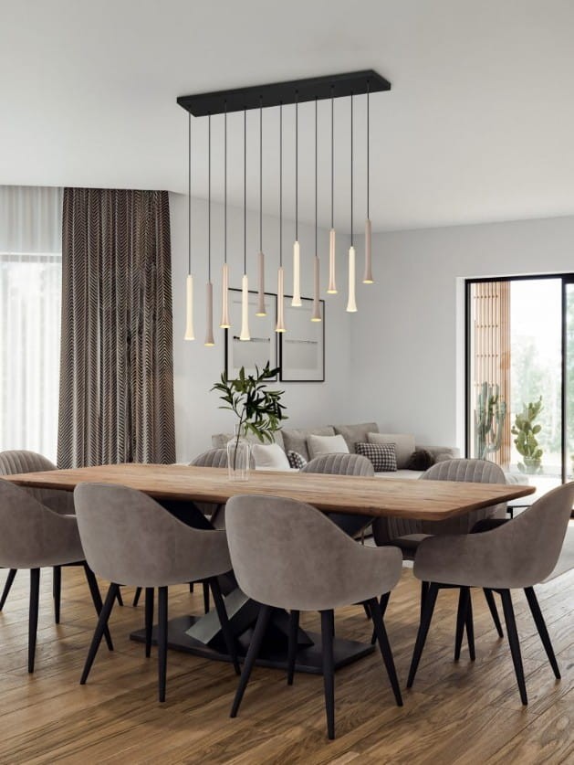 Lampa wisząca Fiato z 11 źródłami LED, o mocy 33W, w czarnej obudowie z multikolorowymi kloszami, zawieszona na prostokątnej podstawie. Umieszczona nad drewnianym stołem w nowoczesnej jadalni, otoczona szarymi krzesłami.
