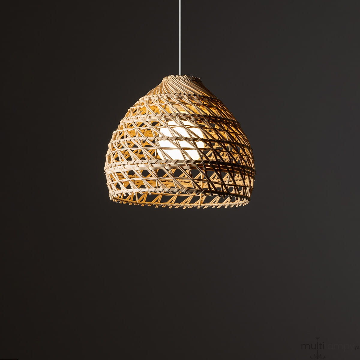 Lampa wisząca Boho S w kolorze białym i rattanowym, z okrągłym kloszem o strukturalnym wzorze. Zawieszona na cienkim, białym przewodzie. Klosz ma kształt przypominający kosz, tworząc efektowne oświetlenie. Tło ciemne, podkreślające detal lampy.