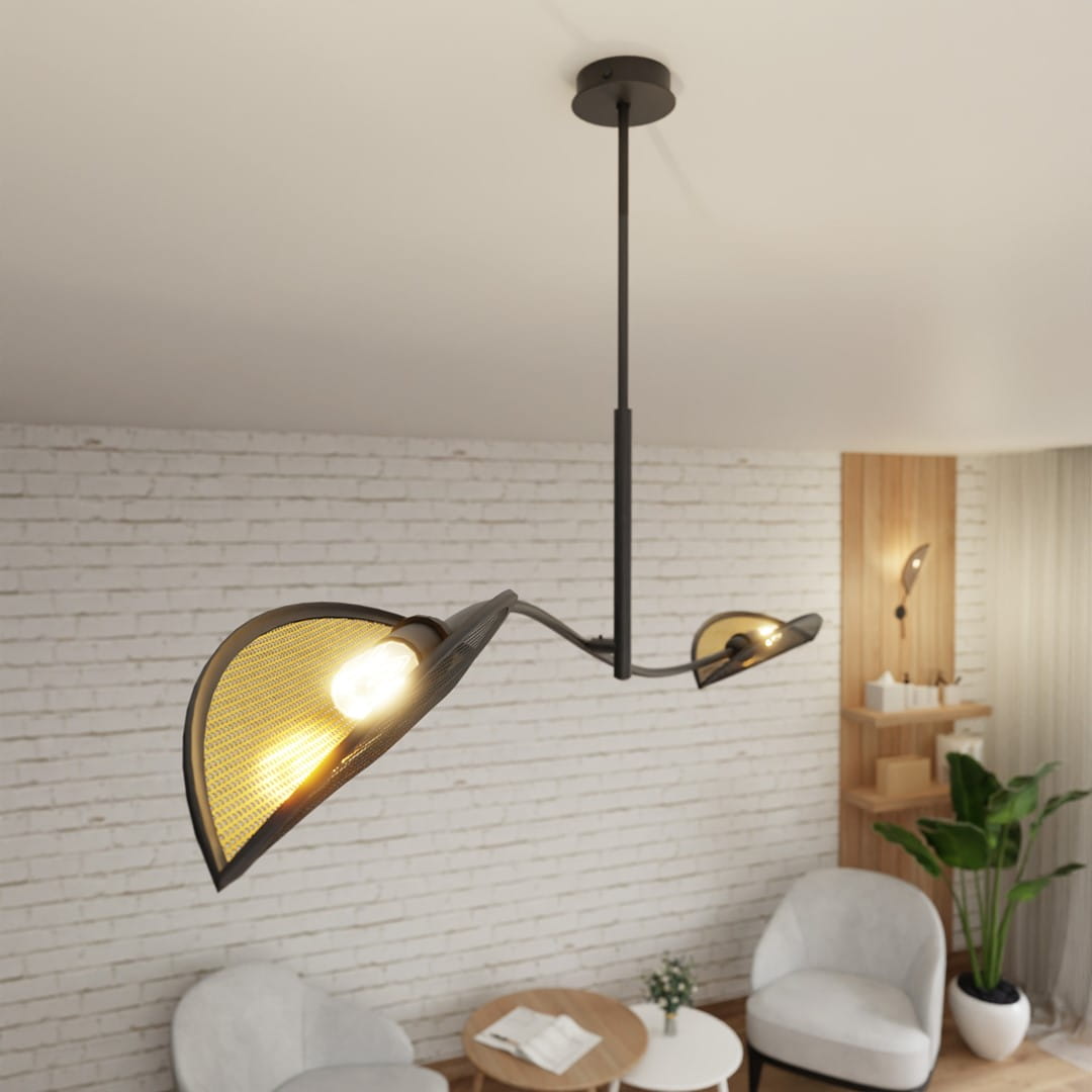 Lampa sufitowa Lotus 2-punktowa w kolorze czarnym i złotym. Posiada dwa klosze o kształcie liści, zawieszona na długim, cienkim ramieniu. Tło to jasna ceglana ściana, a w otoczeniu widoczne meble i rośliny.