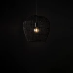 Lampa wisząca Haiti Black S, czarna, o zaokrąglonym kształcie, wykonana z metalowego drutu. Zawiera jedno miejsce na żarówkę E27. Produkt zawieszony w powietrzu, na jednolitym, ciemnym tle.