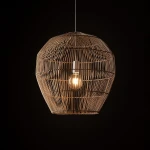 Lampa wisząca Haiti, w naturalnym kolorze, z plecionki z włókien, o kształcie stożka, z widoczną żarówką E27 w środku, zawieszona na cienkim przewodzie, na ciemnym tle.