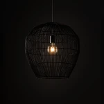 Lampa wisząca Haiti Black M w czarnym kolorze, wykonana z cienkich prętów, o kształcie owalnym. Widoczna żarówka E27 w centralnej części, zawieszona na cienkim kablu, na ciemnym tle, podkreślająca minimalistyczny design.