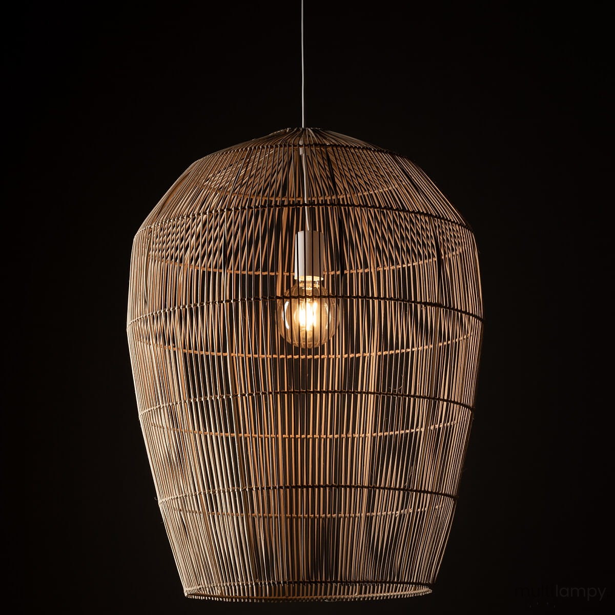 Lampa wisząca Haiti w kolorze białym i naturalnym, wykonana z plecionego materiału, o kształcie bębna. Widoczna żarówka E27 w środku. Zawieszona na cienkim przewodzie, na ciemnym tle. Idealna do nowoczesnych wnętrz.