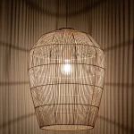 Lampa wisząca Haiti L w kolorze białym i naturalnym, z metalowym kloszem w formie owalnej, z widoczną żarówką E27. Ujęcie z góry, pokazujące detale struktury klosza oraz cień rzucany na ścianę.
