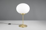 Lampa stołowa Fomento 1xE27 w kolorze mosiądzu z białym, okrągłym kloszem. Produkt stoi na okrągłej podstawie, z widocznym kablem z włącznikiem. Tło w odcieniu szaro-beżowym, podkreślające elegancki design lampy.