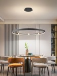 Lampa wisząca Pignano z 7 żarówkami LED, o mocy 54W, w kolorze czarnym i złotym. Okrągły kształt, zawieszona na cienkich linkach, umieszczona nad okrągłym stołem w nowoczesnej aranżacji. Tło z jasnymi ścianami i meblami.
