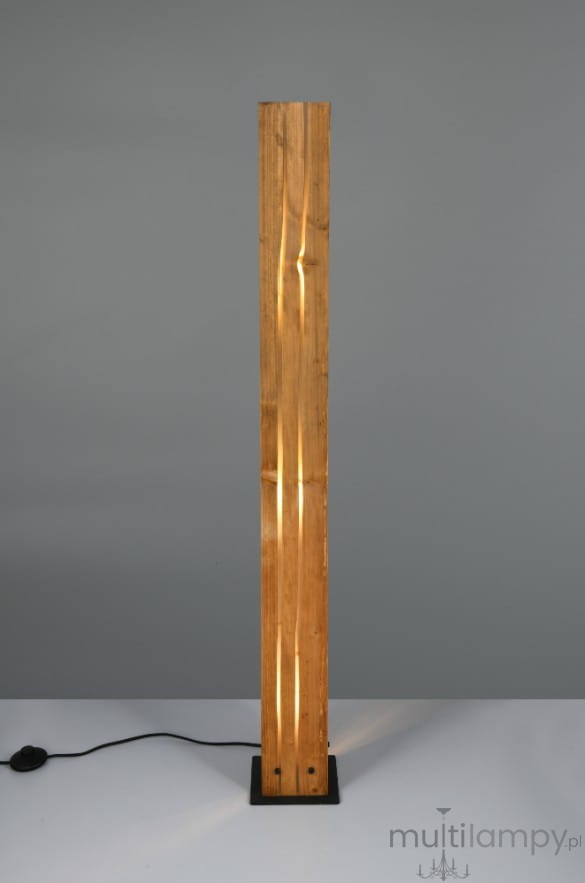 Lampa podłogowa Karuni z czarną podstawą i jasnym drewnem w formie prostokątnego słupa. Widoczne szczeliny w drewnie emitujące światło. Ułożona w pionie, na gładkim tle. Kabel z włącznikiem widoczny obok podstawy.