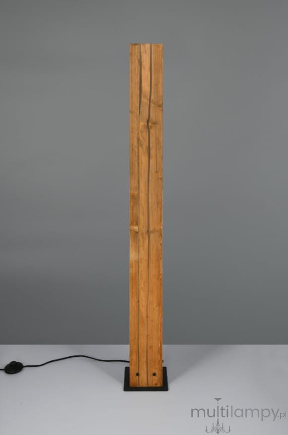 Lampa podłogowa Karuni z podstawą w kolorze czarnym i prostokątnym trzonem z jasnego drewna, stojąca w pozycji pionowej. Widoczny kabel z włącznikiem. Tło szare, minimalistyczne.