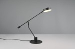 Czarna lampa biurkowa Manduro z regulowanym ramieniem, wyposażona w 1 diodę LED o mocy 6W. Stojąca na okrągłej podstawie, z okrągłym kloszem, emitującym ciepłe światło. Ujęcie z boku, na jednolitym tle.