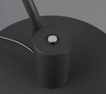 Czarna lampa biurkowa Manduro z wbudowanym źródłem światła LED 6W. Ujęcie z góry, pokazujące okrągłą podstawę oraz przycisk włączający z metalowym wykończeniem. Kabel zasilający w widoku.