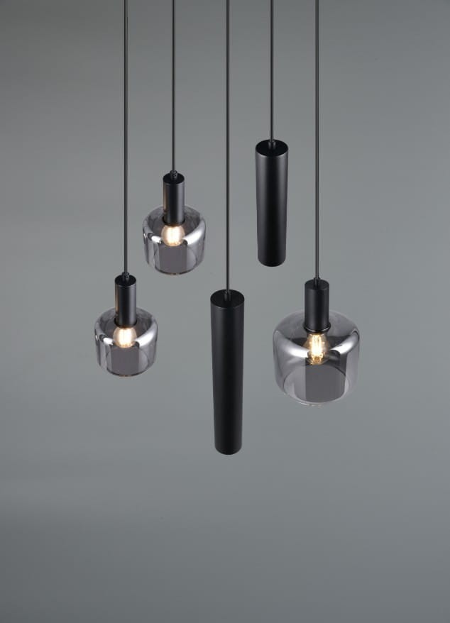 Lampa wisząca Mataro w kolorze czarnym z pięcioma źródłami światła E27/E14/GU10. Elementy w formie cylindrycznych i kulistych kloszy, umieszczone na cienkich przewodach. Tło w odcieniu szarości, podkreślające nowoczesny design.