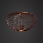 Lampa wisząca Pumpkin M w kolorze ceglanym, wykonana z cienkich metalowych prętów w formie otwartej czaszy. Ujęcie z góry, pokazujące detal konstrukcji oraz miejsce na żarówkę GU10. Czarny kabel zawieszający na tle ciemnym.