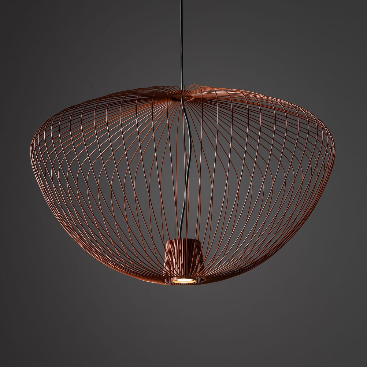 Lampa wisząca Pumpkin L w kolorze ceglanym, wykonana z metalowej siatki w kształcie miski. Posiada miejsce na jedną żarówkę GU10, zawieszona na cienkim przewodzie. Ujęcie z góry, na ciemnym tle.