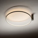 Lampa sufitowa Circolo M w kolorze oliwkowym, z okrągłym kloszem i montażem na ścianie. Wbudowane oświetlenie LED o mocy 21W i temperaturze barwowej 3000K. Ujęcie z góry, ukazujące minimalistyczny design i delikatne światło.