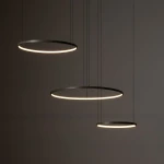 Lampa wisząca Circolo D125 z trzema okrągłymi elementami, w kolorze oliwkowym. Źródło światła LED o mocy 45W i temperaturze barwowej 3000K. Ujęcie z przodu, zawieszona na cienkich linkach, minimalistyczny design.