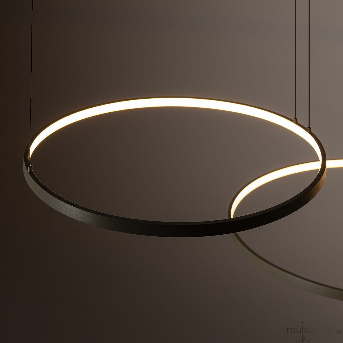 Lampa wisząca Circolo D125 w kolorze oliwkowym, z trzema źródłami światła LED o mocy 45W i temperaturze barwowej 3000K. Posiada okrągły kształt z subtelnym podświetleniem, zawieszona na cienkich linkach, widok z góry.