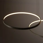 Lampa wisząca Circolo D125 w kolorze oliwkowym, z trzema źródłami światła LED o mocy 45W i temperaturze barwowej 3000K. Posiada okrągły kształt z subtelnym podświetleniem, zawieszona na cienkich linkach, widok z góry.