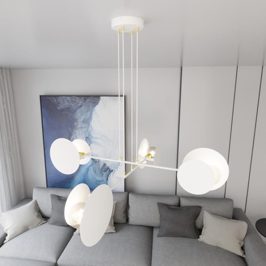 Lampa wisząca Idea 4-punktowa w kolorze białym, z okrągłymi kloszami i złotymi elementami, zawieszona na cienkich linkach. Ujęcie z góry, z widocznym tłem w postaci szarej kanapy i abstrakcyjnego obrazu.