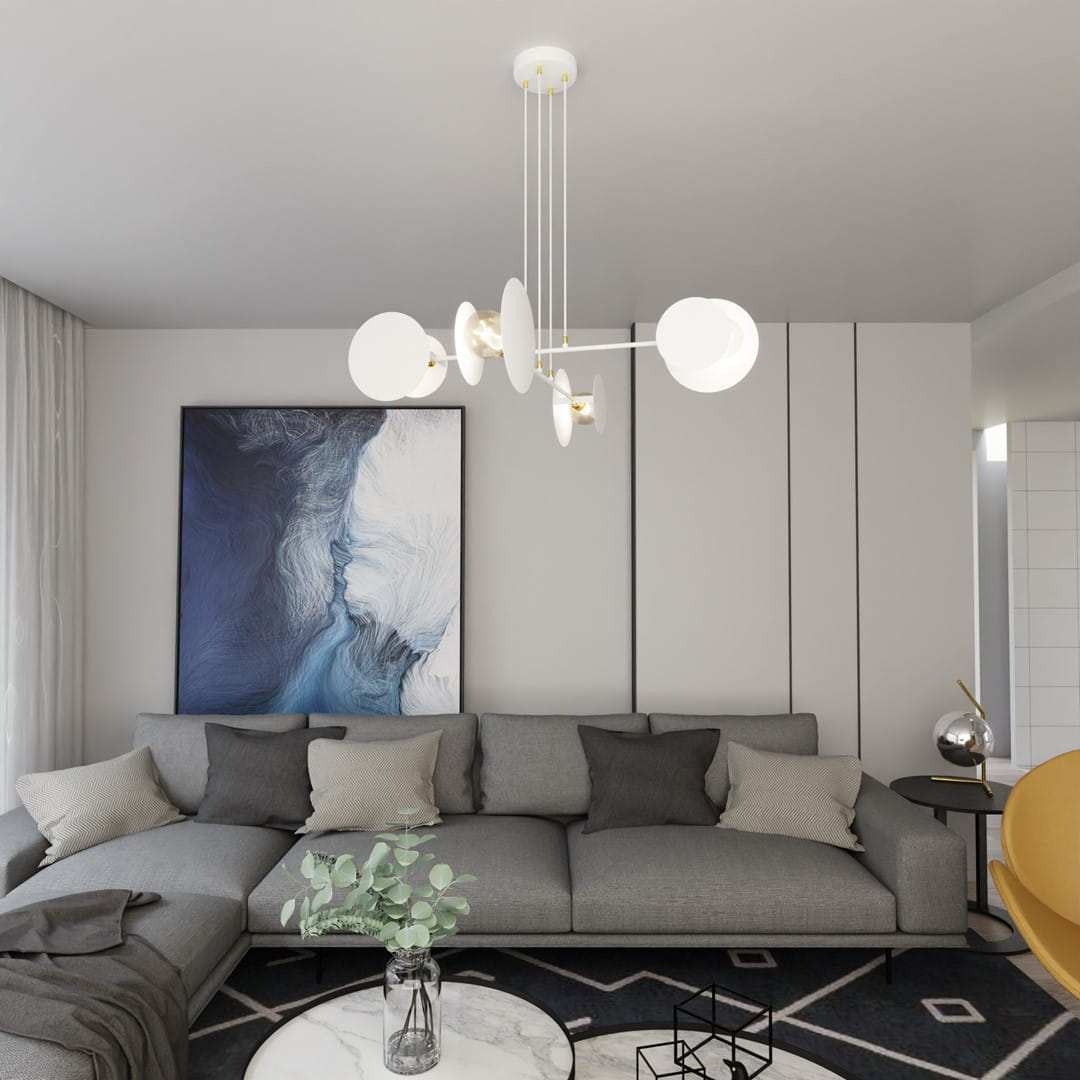 Lampa wisząca Idea 4-punktowa w kolorze białym z minimalistycznymi kloszami, zawieszona na długich linkach. Umieszczona nad szarej sofie w nowoczesnym wnętrzu z obrazem na ścianie i okrągłym stolikiem.